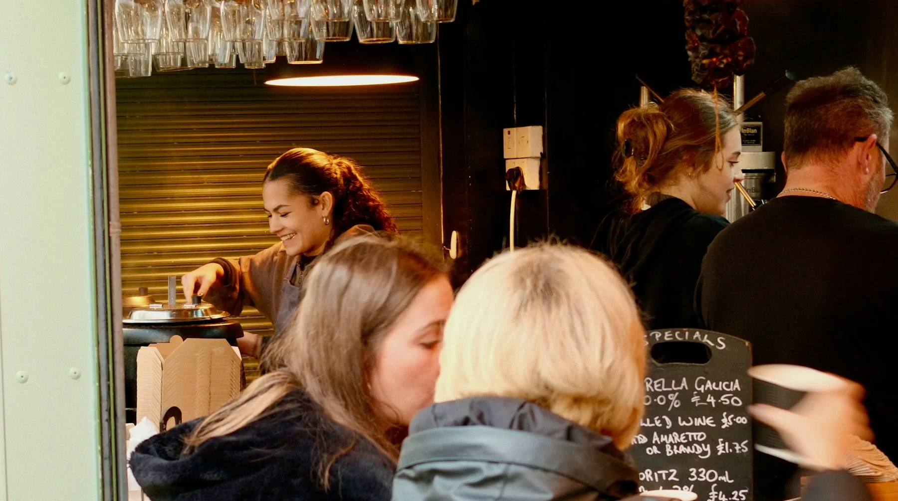 Cafe staff serving customers at a busy counter